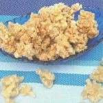 Puffed Rice Snacks In A Blue Bowl From Dm Traders Organic Store On A Striped Fabric Background.