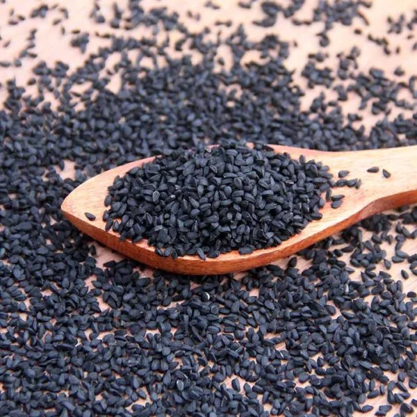 Wooden Spoon With Black Seeds From Dm Traders Organic Store On A Wooden Surface.